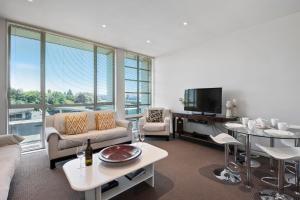 a living room with a couch and a tv at Marinaside Villa - Taupo Holiday Apartment in Taupo