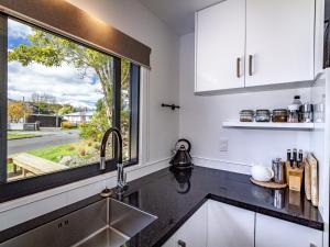 uma cozinha com um lavatório e uma janela em Mountain Magic - Ohakune Holiday Home em Ohakune