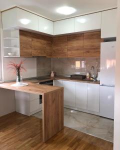 cocina con armarios blancos y encimera de madera en B&S stan na dan, en Bijeljina