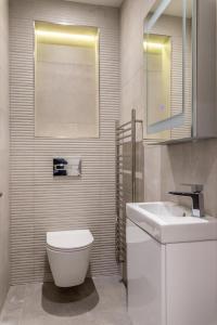 a bathroom with a white toilet and a sink at Modern&Luxurios 1 Bed Apartment-Prime Location. in London
