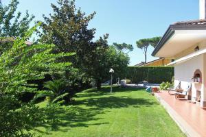 un patio con césped verde y una casa en La Pedica B&B, en Grottaferrata