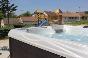 a jacuzzi tub in front of a playground at Neidhardt Vendégház in Bóly