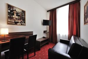 Habitación de hotel con sofá y escritorio en Hotel Centrum Sosnowiec, en Sosnowiec