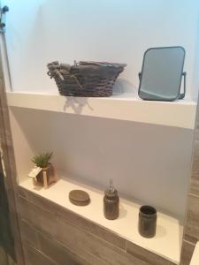 Un estante con dos ollas y una cesta. en Appartement calme, en Saint-Maixent-lʼÉcole