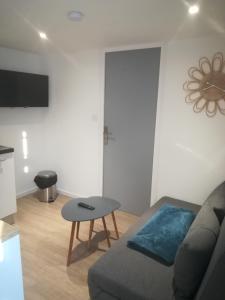 a living room with a couch and a table at Appartement calme in Saint-Maixent-lʼÉcole