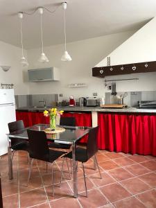 a kitchen with a table and chairs and red curtains at Il Fienile in Garessio