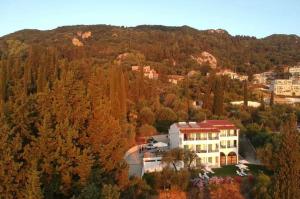 a large house in the middle of a forest at Nikoli Apartments in Benitses