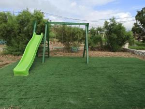 un parco giochi con uno scivolo verde sull'erba di BlueTel Lixouri a Lixouri