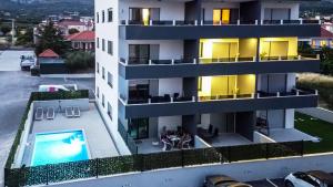 - une vue aérienne sur un bâtiment avec une piscine dans l'établissement Apartments Angelus, à Trogir