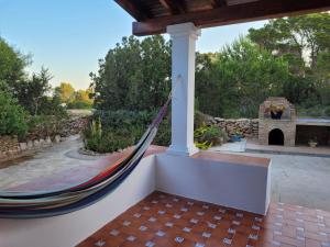 a hammock on a porch with a fireplace at Can Brilla in Sant Francesc Xavier