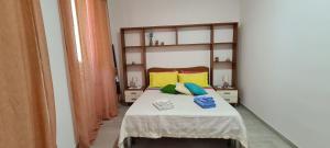 - une chambre avec un lit doté d'oreillers jaunes et bleus dans l'établissement CASA SiSSi, à Augusta