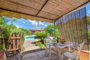 a patio with a table and chairs and a pool at Cottage Soraya with independent swimming pool near the beach in Sassari