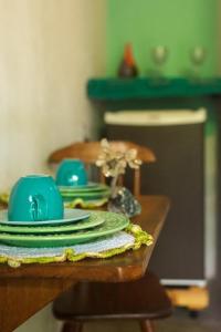 a table with green plates and blue dishes on it at Pousada São Miguel Filosofal in São Miguel do Gostoso +33 photos