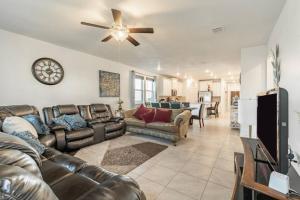 a living room with leather furniture and a ceiling fan at Modern 5 Bedroom with access to community pool in Austin