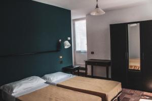 1 dormitorio con 2 camas y pared verde en Da Laura, en Brunate