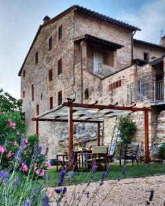 une table et des chaises devant un bâtiment dans l'établissement Casa Santa Giulia, à Monteriggioni