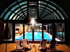 a room with chairs and a swimming pool at Deluxe Villa Coast River Sarajevo in Visoko