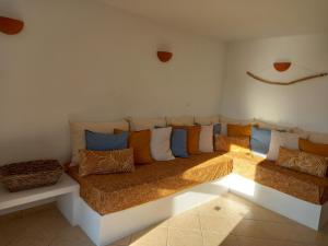 a couch with many pillows on it in a room at Madilida Sifnos Apartment in Artemonas
