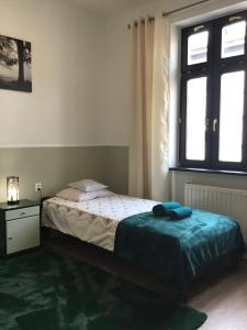 mała sypialnia z łóżkiem i oknem w obiekcie Goldengreen Apartment w Krakowie