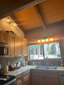 a kitchen with wooden cabinets and a sink and a window at Indian Hills Gem Awaits in Truckee