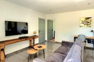 a living room with a couch and a flat screen tv at MAISON PLEIN-PIED DÉTENTE ASSUREE Clim-BBQ in Varetz