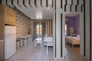 a kitchen and a living room with a clock on the wall at Potamaki Studios & Apartments in Stoupa