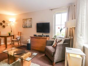 a living room with a couch and a tv at Cosy Corner in the Lakes in Penrith