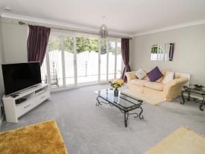 a living room with a couch and a tv at Mountain Ash in Rhyl