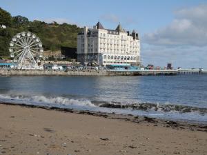 a building on the beach with a ferris wheel at Mountain Ash in Rhyl