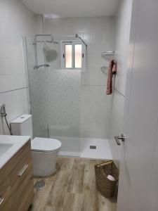 APARTAMENTO SH في مالقة: حمام ابيض مع مرحاض ودش