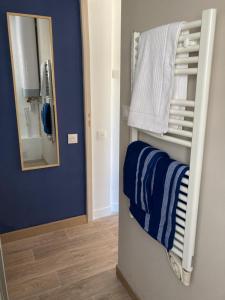 a bathroom with blue walls and a mirror and towels at La Capitane in La Baule