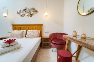 a bedroom with a bed and a desk and a chair at Luxury House Niso in Skala Sotiros