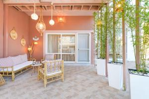 a patio with chairs and a table and potted plants at Luxury House Niso in Skala Sotiros