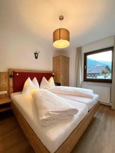 - une chambre avec un grand lit et une grande fenêtre dans l'établissement Ferienappartements Heinzle - Ihr Ferienresort, à Sankt Jakob in Defereggen