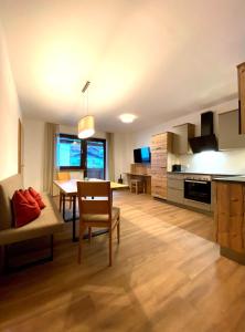 a kitchen and living room with a table and a couch at Ferienappartements Heinzle - Ihr Ferienresort in Sankt Jakob in Defereggen