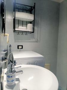 bagno con lavandino e mensola con asciugamani di Hakuna Matata ,grazioso appartamento in centro a Caserta