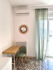 a dining room with a table and a green chair at La Vue est Belle - Puglia Mia Apartments in Monopoli