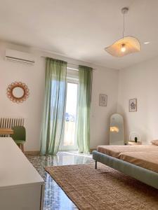a bedroom with a bed and a large window at La Vue est Belle - Puglia Mia Apartments in Monopoli