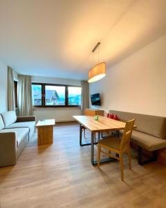 ein Wohnzimmer mit einem Sofa und einem Tisch in der Unterkunft Ferienappartements Heinzle - Ihr Ferienresort in Sankt Jakob in Defereggen