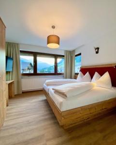 a bedroom with a large bed with a large window at Ferienappartements Heinzle - Ihr Ferienresort in Sankt Jakob in Defereggen