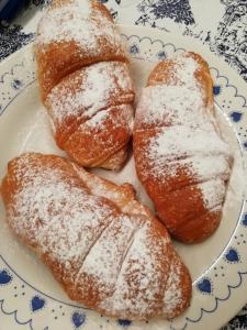 quattro pasticcini su un piatto con zucchero in polvere di CastelCharme b&b a Pergine Valsugana