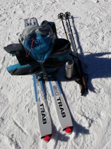 ペルジーネ・ヴァルスガーナにあるCastelCharme b&bの雪中のスキー用具、バックパック、スキー用具