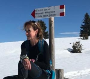 a woman sitting next to a sign in the snow at CastelCharme b&b in Pergine Valsugana