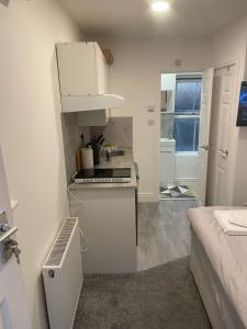 a small white kitchen with a counter and a room at Luton Short Term Lets - Cardiff Road in Luton