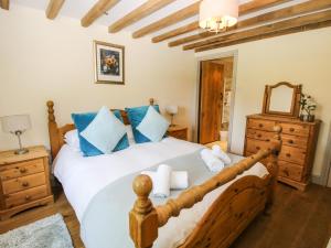 a bedroom with a large white bed with blue pillows at The Wain House in Acton Scott