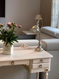a white table with a lamp and flowers on it at Bulls Haven Villa Kristiansand in Kristiansand