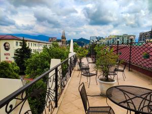 un balcón con sillas, mesas y una ciudad en Aparthotel Old City, en Batumi