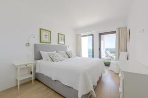 a white bedroom with a bed and a window at Ken Blacklock in Fuzeta +65 photos