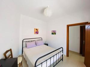 a bedroom with a bed with purple pillows at Chrisa's Guest House in Skala Potamias