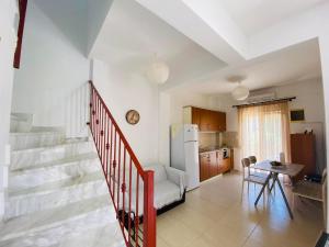 a living room with a staircase and a kitchen at Chrisa's Guest House in Skala Potamias
